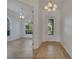 Bright entryway with tile flooring, chandelier, adjacent room, and view through front door at 11840 Eagle Ray Lane, Orlando, FL 32827