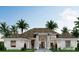Modern coastal home with white exterior, dark roof, palm trees, and a welcoming front entrance at 17050 Medici Way, Bella Collina, FL 34756