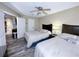 Two beds in a bedroom with ceiling fan, wood-look tile, and open doorway at 3100 Parkway Blvd # 110, Kissimmee, FL 34747