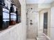 Close-up of walk-in shower with tile walls, dual shower heads, and shelving with toiletries at 3100 Parkway Blvd # 110, Kissimmee, FL 34747