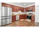 Modern kitchen featuring stainless steel appliances, ample counter space, and rich wood cabinetry at 4392 Wardell Pl # 102, Orlando, FL 32814