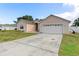 Front exterior of a single-story home with attached two-car garage and concrete driveway at 686 Cotulla Dr, Kissimmee, FL 34758