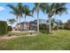 View of the home's exterior with lush landscaping and pool enclosure at 715 Sanctuary Dr, Oviedo, FL 32766