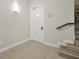 Townhome entryway with white door, tiled floor, and staircase at 7770 Sandy Ridge Dr # 114, Reunion, FL 34747