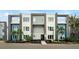 Modern townhome with blue and gray siding, balconies, and lush landscaping at 7770 Sandy Ridge Dr # 114, Reunion, FL 34747