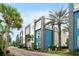 Street view of townhomes with blue and gray siding, balconies, and palm trees at 7770 Sandy Ridge Dr # 114, Reunion, FL 34747