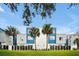 Modern townhome with blue and white exterior, lush landscaping, and palm trees at 7770 Sandy Ridge Dr # 114, Reunion, FL 34747