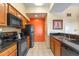 Well-equipped kitchen featuring wood cabinets, black appliances, and granite countertops at 8112 Poinciana Blvd # 1709, Orlando, FL 32821
