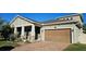Two-story house with light green exterior, brown garage door, and landscaped yard at 3811 Island Green Way, Orlando, FL 32824