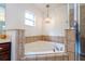 Relaxing corner bathtub with tile surround and window at 11410 Rapallo Ln, Windermere, FL 34786