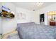 Comfortable bedroom with gray bedding and a large wall-mounted TV at 11410 Rapallo Ln, Windermere, FL 34786