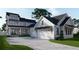Modern farmhouse features gray and white exterior, black roof, and a spacious driveway at 1258 Ridge Lake Way, Oakland, FL 34787