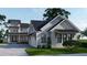 Two-story farmhouse style home with gray siding, black roof, and attached garage at 1258 Ridge Lake Way, Oakland, FL 34787
