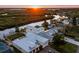 Sunset aerial view showcasing home, pool, dock, and waterfront location at 25 Cunningham Dr, New Smyrna Beach, FL 32168