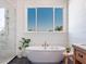 Modern bathroom with freestanding tub, glass shower, and large window at 25 Cunningham Dr, New Smyrna Beach, FL 32168