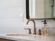 Close-up of a modern gold faucet with running water and marble countertop at 25 Cunningham Dr, New Smyrna Beach, FL 32168