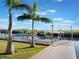 Dock with seating, boat lift, and lush landscaping along the water at 25 Cunningham Dr, New Smyrna Beach, FL 32168