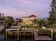 Evening view of home's exterior, pool, and dock from the water at 25 Cunningham Dr, New Smyrna Beach, FL 32168