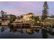 Waterfront home with private dock at sunset, reflecting in the calm water at 25 Cunningham Dr, New Smyrna Beach, FL 32168