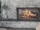 Cozy fireplace with a roaring fire, stone surround, and a decorative lantern at 25 Cunningham Dr, New Smyrna Beach, FL 32168