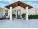 Charming front entrance with a covered porch, gray door, and potted plants at 25 Cunningham Dr, New Smyrna Beach, FL 32168