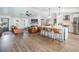 Open-concept living area with hardwood floors, leather furniture, and a view into the kitchen at 25 Cunningham Dr, New Smyrna Beach, FL 32168