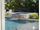 Tranquil pool with a cascading waterfall feature, surrounded by lush landscaping at 25 Cunningham Dr, New Smyrna Beach, FL 32168