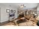 Bright living room with hardwood floors, leather sofas, and a large TV at 28023 Cypress Springs Loop, Okahumpka, FL 34762