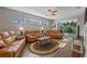 Spacious living room with hardwood floors and tan leather furniture at 28023 Cypress Springs Loop, Okahumpka, FL 34762