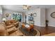 Spacious living room with hardwood floors, comfy leather sofas, and access to a patio at 28023 Cypress Springs Loop, Okahumpka, FL 34762