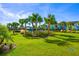 Community pool with palm trees, green space, and colorful buildings at 2956 Caribbean Soul Dr, Kissimmee, FL 34747