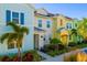 Row of colorful townhouses with palm trees and landscaping at 2956 Caribbean Soul Dr, Kissimmee, FL 34747