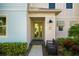 Front entryway with mint green door, bench, and lush landscaping at 2956 Caribbean Soul Dr, Kissimmee, FL 34747