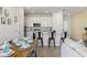 Bright, open kitchen and dining area with white cabinets, stainless steel appliances, and an island with bar seating at 2956 Caribbean Soul Dr, Kissimmee, FL 34747