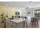 Open concept kitchen and living area with an island, white cabinets, and stainless steel appliances at 2956 Caribbean Soul Dr, Kissimmee, FL 34747