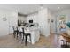 White kitchen with island seating, stainless steel appliances, and tile flooring at 2956 Caribbean Soul Dr, Kissimmee, FL 34747
