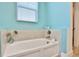 Relaxing bathroom with soaking tub and light blue walls at 3056 Parrot Head Pl, Kissimmee, FL 34747