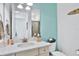 Clean bathroom with a quartz vanity, large mirror, and a teal accent wall at 3056 Parrot Head Pl, Kissimmee, FL 34747