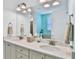 Double vanity bathroom with quartz countertops and modern lighting at 3056 Parrot Head Pl, Kissimmee, FL 34747
