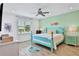 Spacious bedroom with teal bed frame, ocean decor, and a view at 3056 Parrot Head Pl, Kissimmee, FL 34747