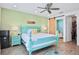 Bedroom with teal bed frame, mini-fridge, and access to bathroom at 3056 Parrot Head Pl, Kissimmee, FL 34747
