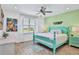 Bright bedroom with teal bed frame and ceiling fan at 3056 Parrot Head Pl, Kissimmee, FL 34747