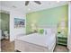 Bedroom with white bed frame, lime green wall, and ensuite bath at 3056 Parrot Head Pl, Kissimmee, FL 34747