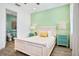 Bedroom with white furniture, en-suite bathroom, and green walls at 3056 Parrot Head Pl, Kissimmee, FL 34747
