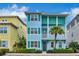 Two-story light blue house with teal accents, a balcony, and palm trees at 3056 Parrot Head Pl, Kissimmee, FL 34747