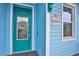 Teal front door with a wreath, next to a light blue house at 3056 Parrot Head Pl, Kissimmee, FL 34747