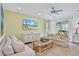 Spacious living room with light beige sofas, a large TV, and wood flooring at 3056 Parrot Head Pl, Kissimmee, FL 34747