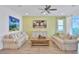 Relaxing living room with light sofas, a large TV, and wood-look tile at 3056 Parrot Head Pl, Kissimmee, FL 34747