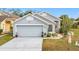Gray house with a two-car garage and landscaping at 3965 Journey Ct, Casselberry, FL 32707