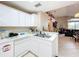 Kitchen boasts white cabinets, dishwasher, and views to living room at 3965 Journey Ct, Casselberry, FL 32707